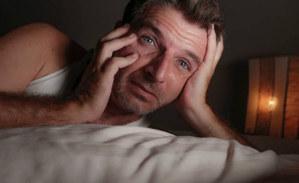 retrato de cerca de cara de hombre atractivo y despierto con los ojos abiertos en la noche acostado en la cama sufriendo insomnio trastorno del sueño tratando de dormir con expresión facial dramática - wide awake fotografías e imágenes de stock