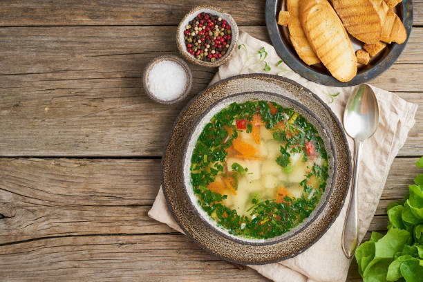 istock Rustic chicken soup with garnish, parsley, vegetables, homemade dish on old dark table, top view, copy space. 1152619800