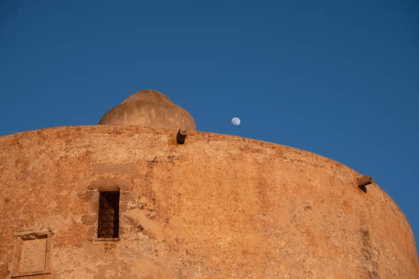 The Sulis Tower and the moon, Alghero (L'Alguer), province of Sassari , Sardinia, Italy. Famous for the beauty of its coast and beaches and its historical city center. Part of its population descends from Catalan conquerors from the end of the Middle Ages. la torre sulis y la luna, alghero (l'alguer), provincia de sassari, cerdeña, italia. famoso por la belleza de su costa y sus playas y su centro histórico de la ciudad. parte de su población desciende de los conquistadores catalanes desde el final de la