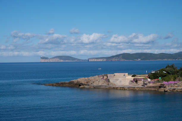 View of Capo Caccia from Alghero (L'Alguer), province of Sassari , Sardinia, Italy. Famous for the beauty of its coast and beaches and its historical city center. Part of its population descends from Catalan conquerors from the end of the Middle Ages. vista de capo caccia de alghero (l'alguer), provincia de sassari, cerdeña, italia. famoso por la belleza de su costa y sus playas y su centro histórico de la ciudad. parte de su población desciende de los conquistadores catalanes desde finales de la ed