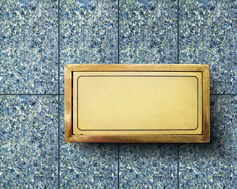 conceptual Close up shot of blank brass nameplate on granite wall of building exterior
