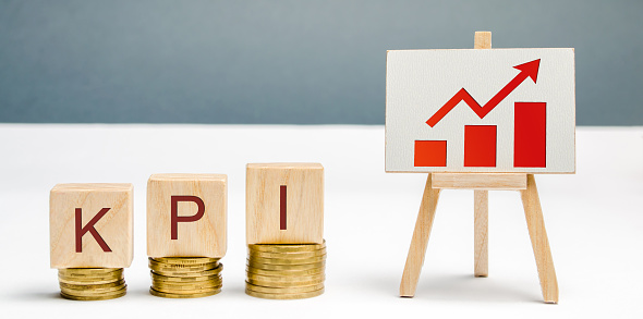 Wooden blocks with the word KPI, the graph with an arrow up. Key Performance Indicator. Planning and implementing a business strategy. Control of business activity of employees and companies