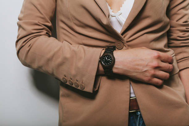istock The girl in a jacket with a clock on her hand 1152621559
