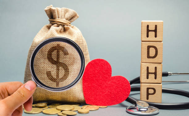 Wooden blocks with the word HDHP and money bag with dollar sign. High-deductible health plan concept. Health insurance plan with lower premiums and higher deductibles than a traditional health plan Wooden blocks with the word HDHP and money bag with dollar sign. High-deductible health plan concept. Health insurance plan with lower premiums and higher deductibles than a traditional health plan free syrian army stock pictures, royalty-free photos & images