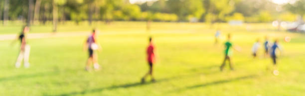 istock Panoramic view blurry background Latin America boys playing soccer at park during sunset 1152623811
