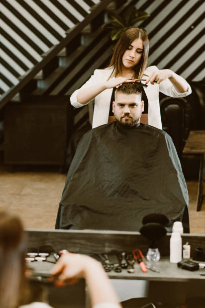 istock the barber cuts a bearded man with scissors in the salon 1152624971