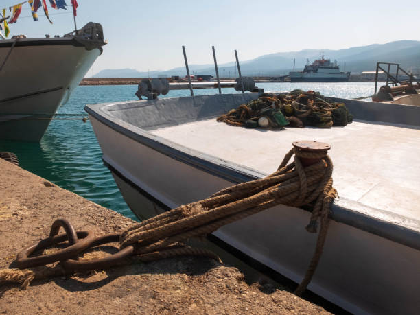 Fishing net lies on the moored fishermen boat Fishing net lies on the moored fishermen boat. bollard pier water lake stock pictures, royalty-free photos & images