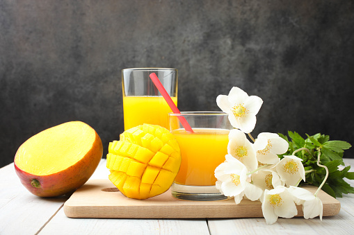 mango, glass with juice and bouquet anemone
