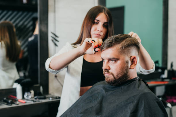 istock the barber cuts a bearded man with scissors in the salon 1152625569