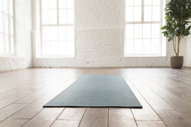 istock Empty room in yoga studio, unrolled yoga mat on floor 1152625689