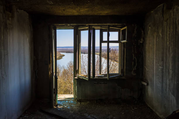istock Broken window overlooking the river in an old, abandoned and burned down building after an earthquake 1152625784