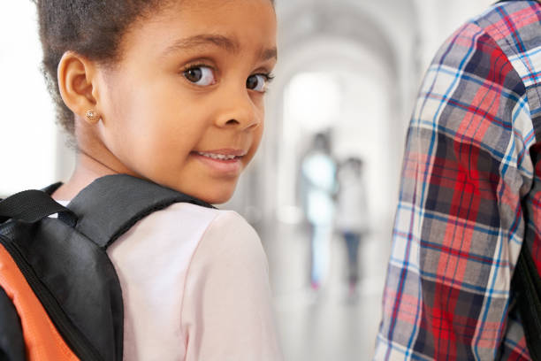 istock Brunette school girl looking at camera over shoulder. 1152637229