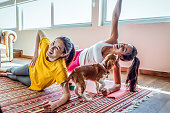 friends exercising together at home in the company of the dog