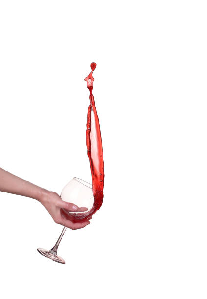 Red wine splashing from glass, isolated on white background