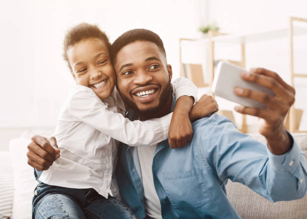 istock Father taking selfie with cute daughter at home 1152640382