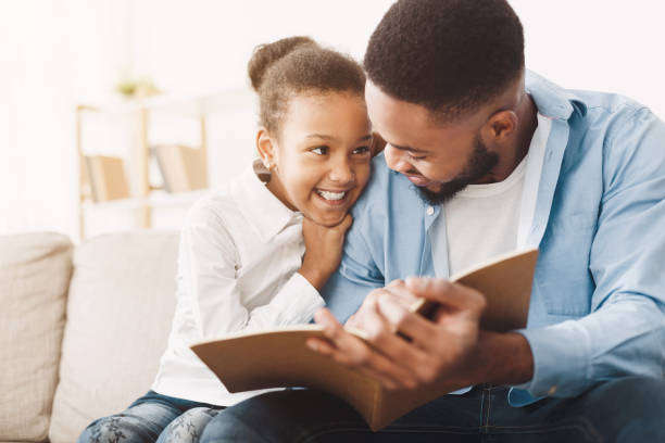 istock African-american dad and daughter spending time, reading book 1152640394
