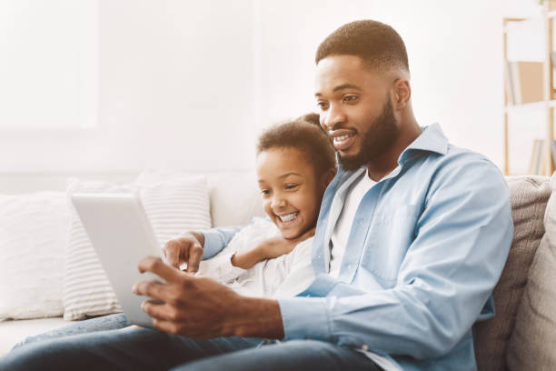 istock Father and daughter watching movie on tablet 1152640404