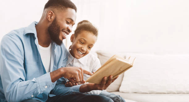 père et fille afro-américains lisant le livre ensemble - family reading african descent book photos et images de collection