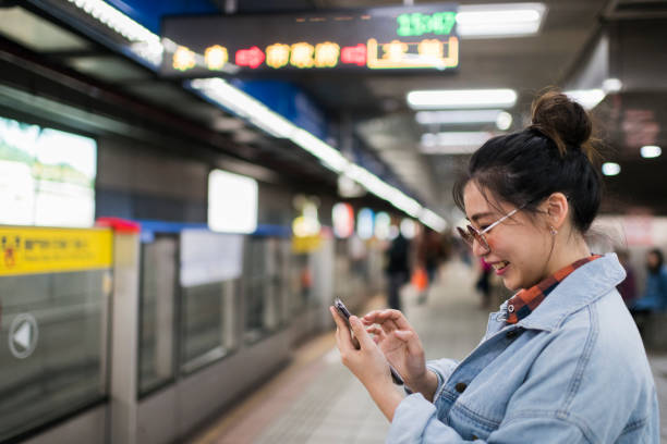 istock Side view young woman typing on phone on subway station 1152644183