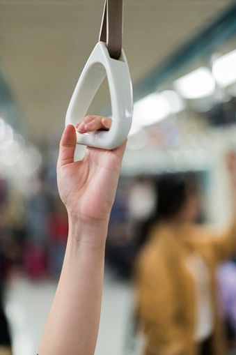 Hand holding safety handle on subway train