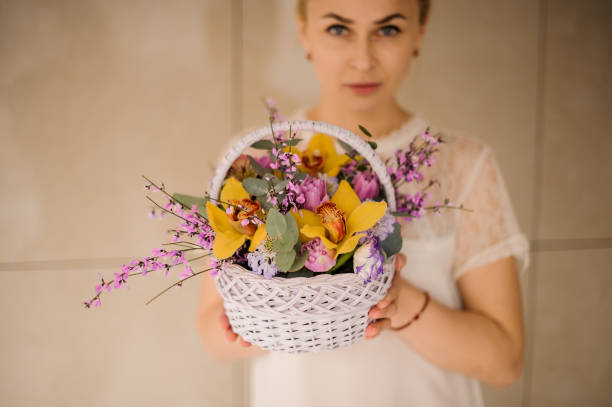 Woman holds a small basket with flowers
