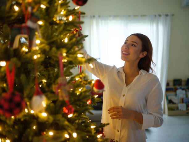 istock Latin woman decorating a christmas tree 1152646323