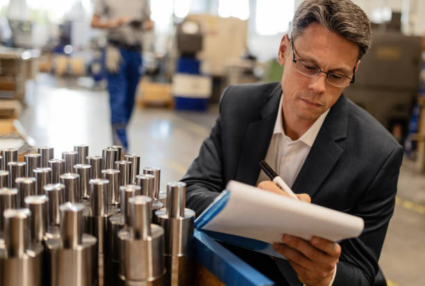 istock Manager writing reports while performing quality control check in a steel factory. 1152649073