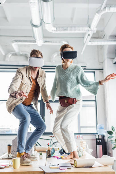 istock female and male designers gesturing with hands while having virtual reality experience in loft office 1152651550