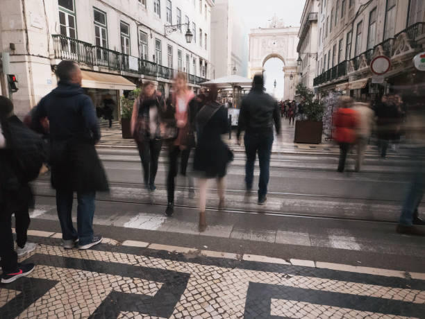 Lisbon, Portugal - April 13, 2019: People cross a perpendicular street to the Rua Augusta street in Lisbon downtown.
