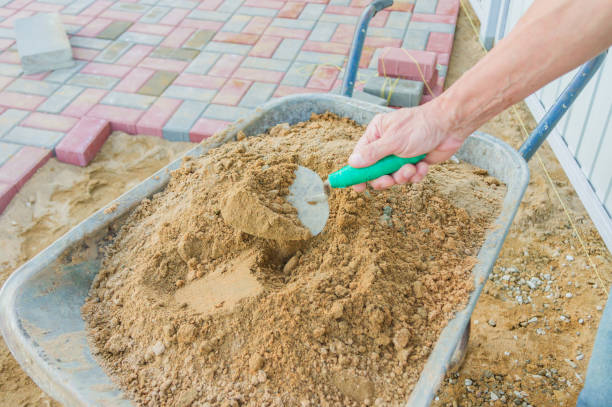 istock Worker laying red and gray concrete paving blocks. Road Paving, construction. 1152653104
