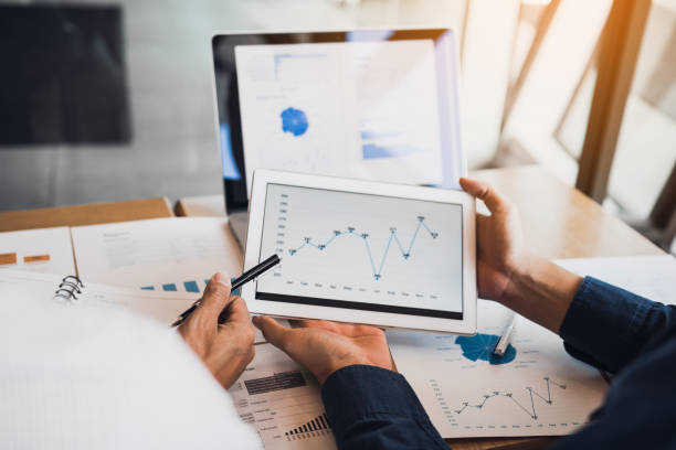 istock Business partnership coworkers using a tablet to chart company financial statements report and profits work progress and planning in office room. 1152653607