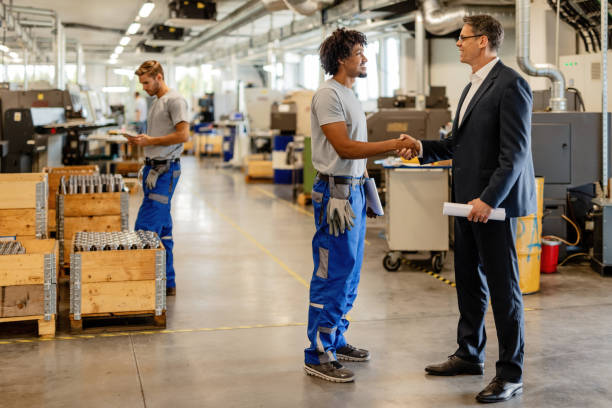 istock Happy engineer and black metal worker greeting in industrial facility. 1152654499