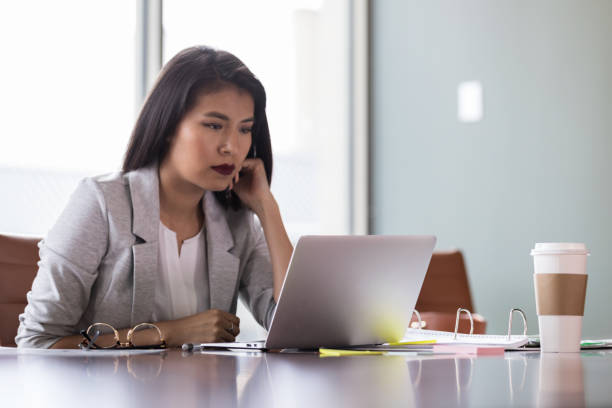 istock Young businesswoman concentrates while using laptop 1152654702