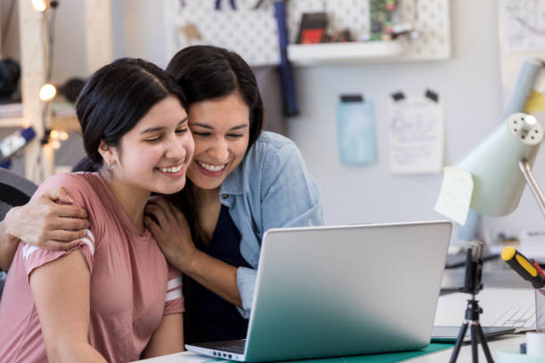 istock Hispanic mother congratulates daughter for completing homework 1152654931