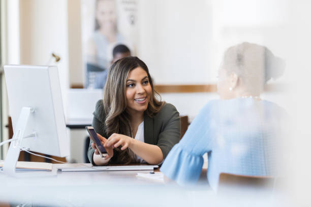 istock Bank employee explains banking app to customer 1152655039