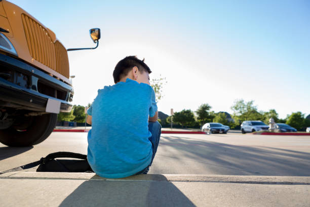 istock Young boy sits on curb after a hard school day 1152655161