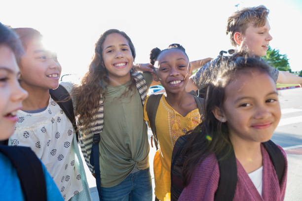 istock Diverse friends bond as they wait for school bus 1152655175
