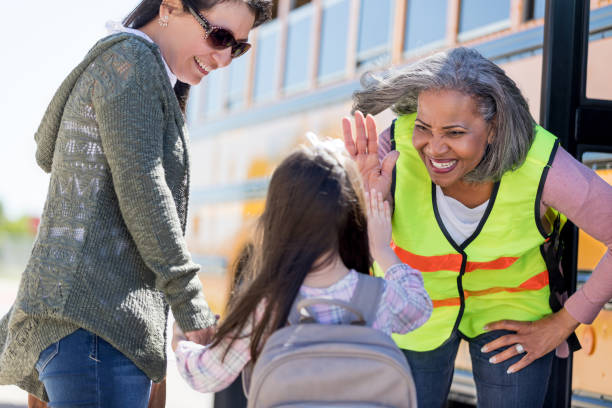 istock Cheerful bus driver gives girl a high five 1152655343