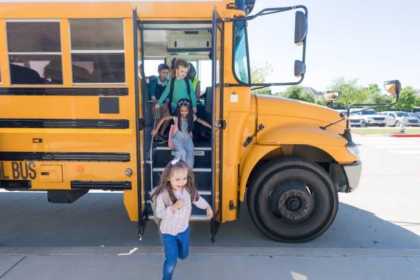 School children exit school bus A group of elementary school children exit bus at the end of the school day. disembarking stock pictures, royalty-free photos & images