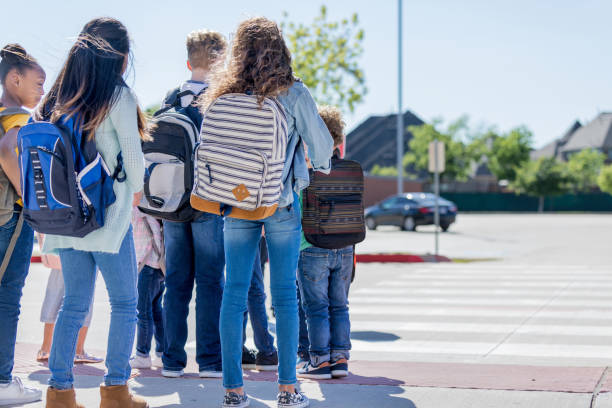 istock School children waiting for school bus 1152655376