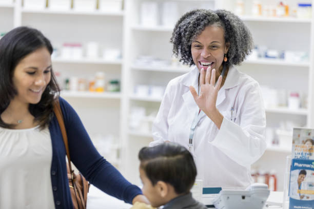 istock Satisfied customers leave pharmacy as pharmacist waves 1152655427