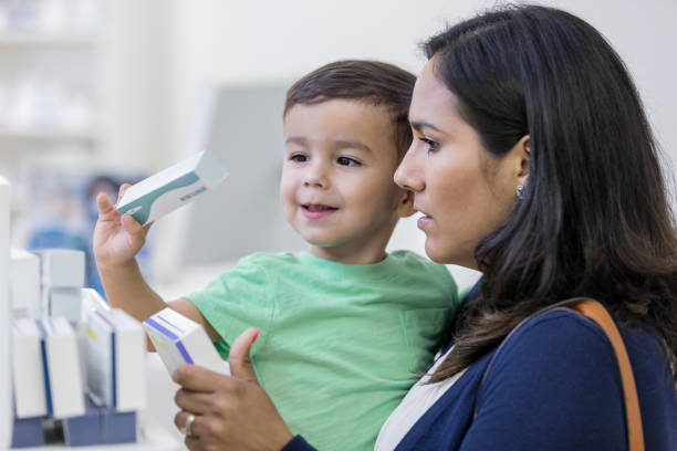 젊은 어머니는 그녀의 유아를 위한 약물 치료를 검색 - carrying reading examining holding 뉴스 사진 이미지
