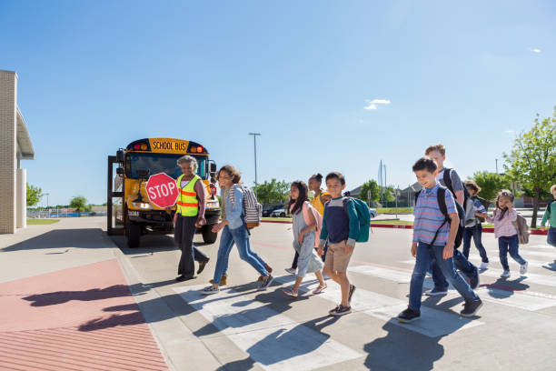 diverse group of children cross safely to school - sinais de cruzamento imagens e fotografias de stock