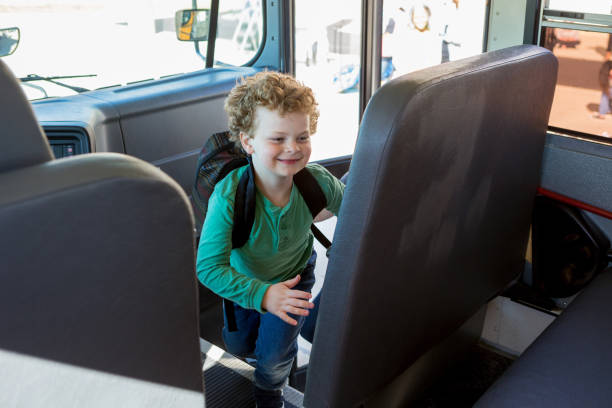 istock Young schoolboy eagerly climbs into school bus 1152655551