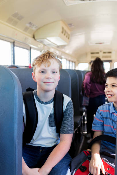 istock Caucasian schoolboy looks at camera while sitting on bus 1152655558