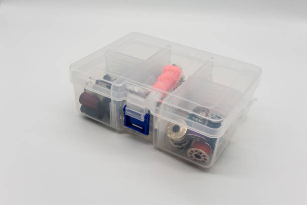 istock Sewing accessories and threads in the clear plastic box isolated on white background. 1152655593