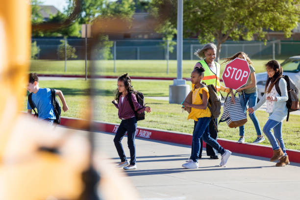 istock Students cross street with crossing guard 1152656283
