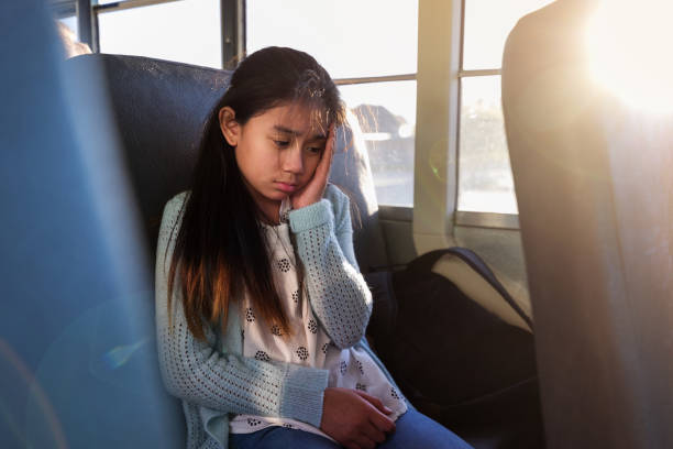 Young female gets car sick on school bus