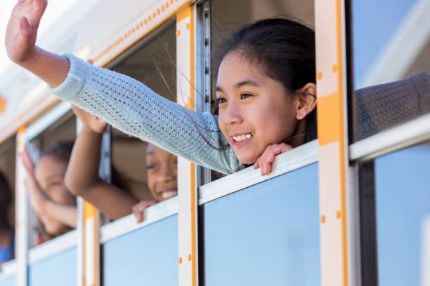 istock Junior high student waves to friends from bus 1152656357