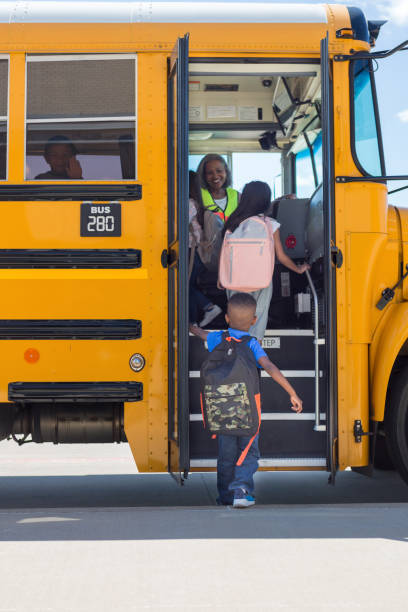 los estudiantes de primaria paso en autobús escolar en línea - niño pre escolar fotografías e imágenes de stock